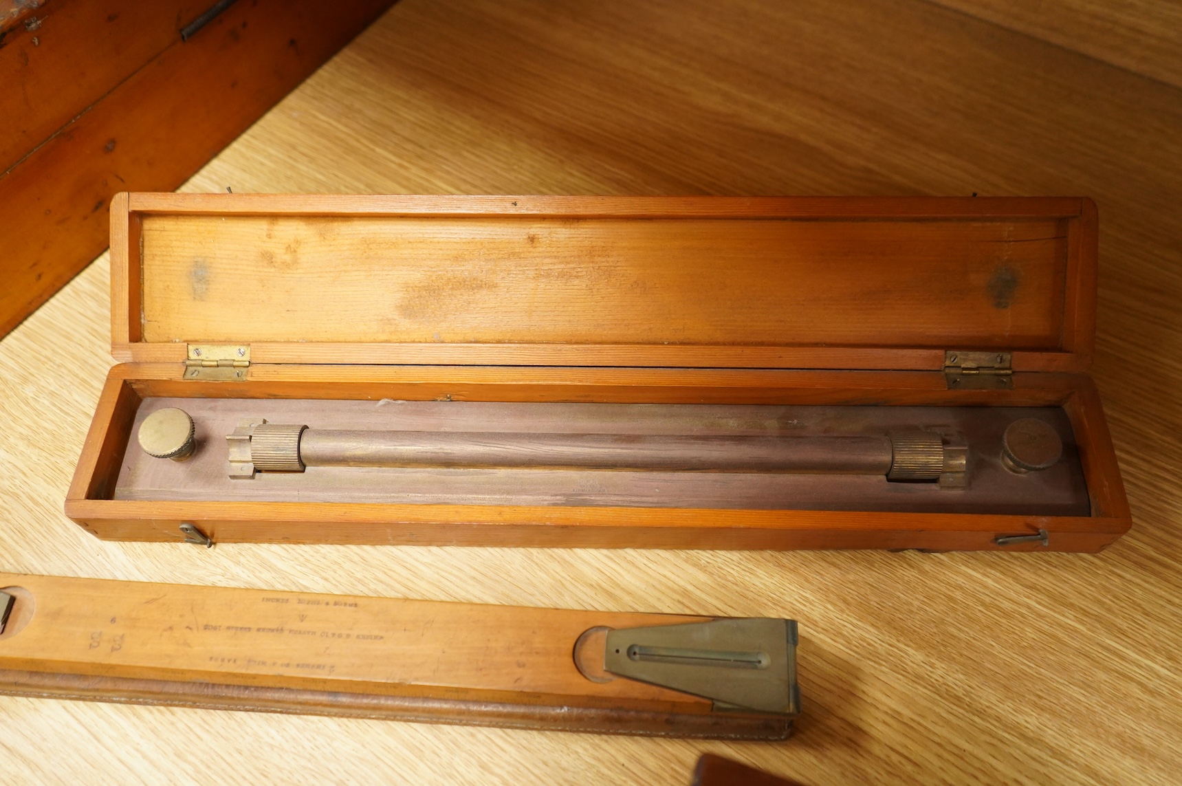 Five scientific instruments, comprising; a rolling parallel rule, pine boxed, 48cm wide; an early 20th century boxwood and brass Alidade, by J. Hicks, 8, 9 & 10, Hatton Garden, leather cased; an oak and brass tripod, sta